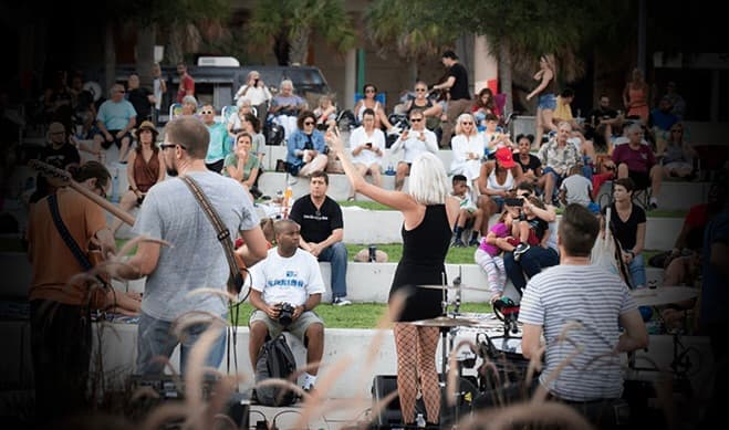 a band performing in a park infront of an audience