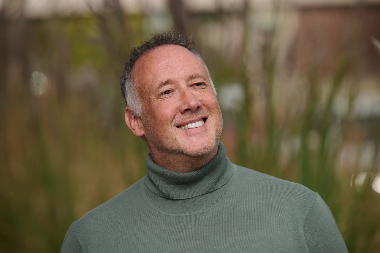 Dan Jahn, strategist, executive advisor and author, smiling outdoors in a green turtleneck